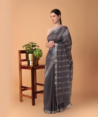 Handwoven linen saree crafted in tie n dyed blue colored base with silver zari border and striped aanchal