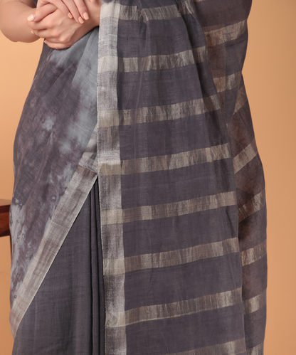 Handwoven linen saree crafted in tie n dyed blue colored base with silver zari border and striped aanchal