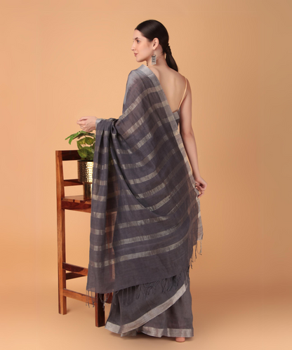 Handwoven linen saree crafted in tie n dyed blue colored base with silver zari border and striped aanchal